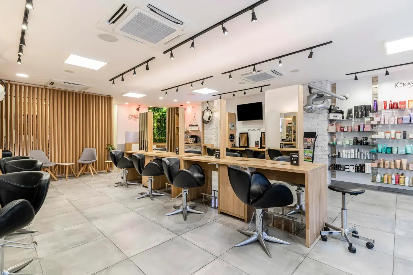 Salon d'Antibes Juan-les-Pins : postes en bois clair et fauteuils noirs