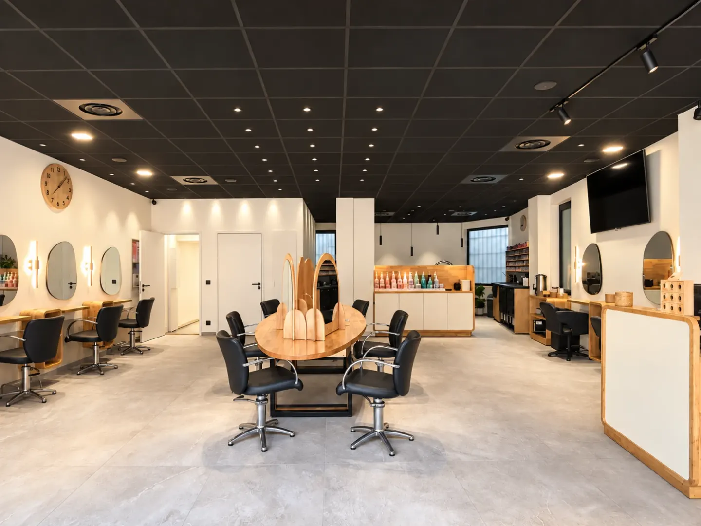 Salon de Cagnes-sur-Mer : grande table ovale en bois au centre, miroirs en arche et plafond noir